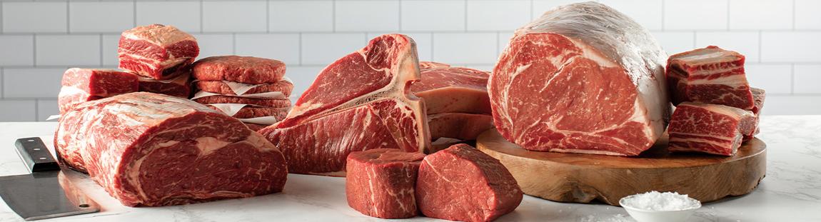 variety of raw steak cuts on a cutting board